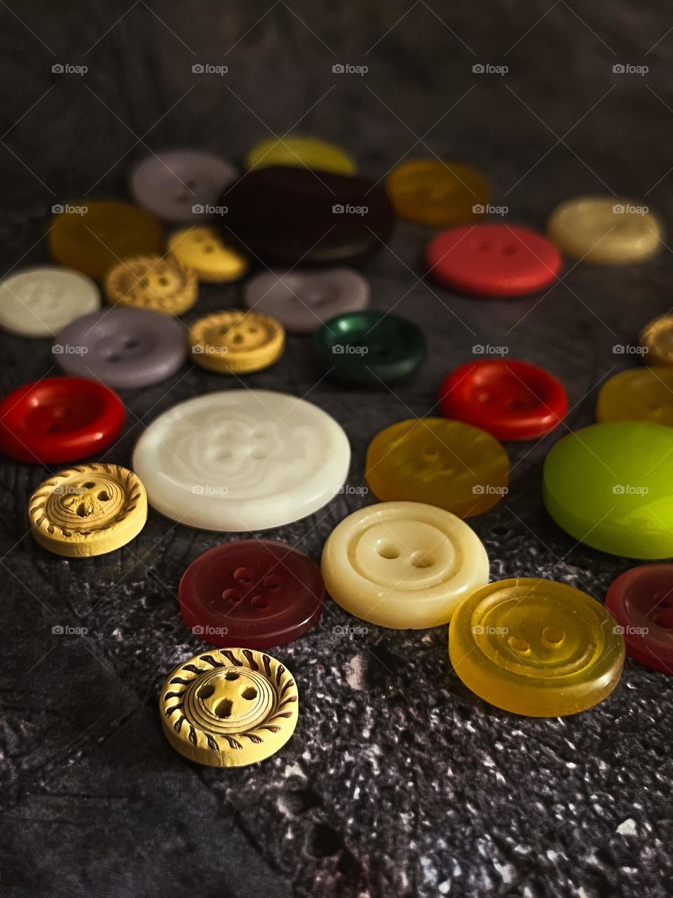 Multicolored buttons scattered on a dark background