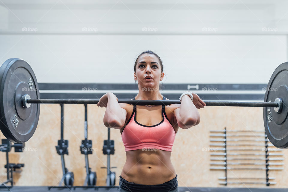 strong sporty woman working out at the gym with barbell - fitness, work out, health