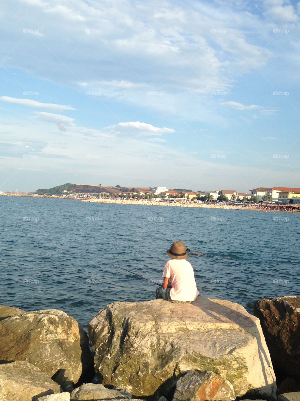 Sitting by the sea. The boy was sitting and fishing by the sea