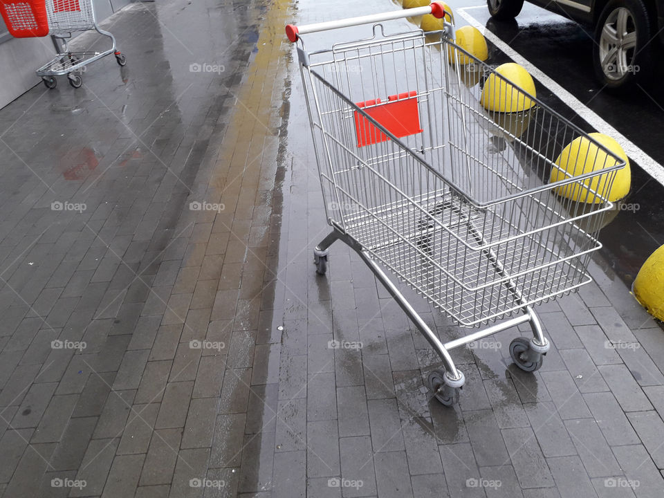 Carts for grocery products stand near a supermarket on the street