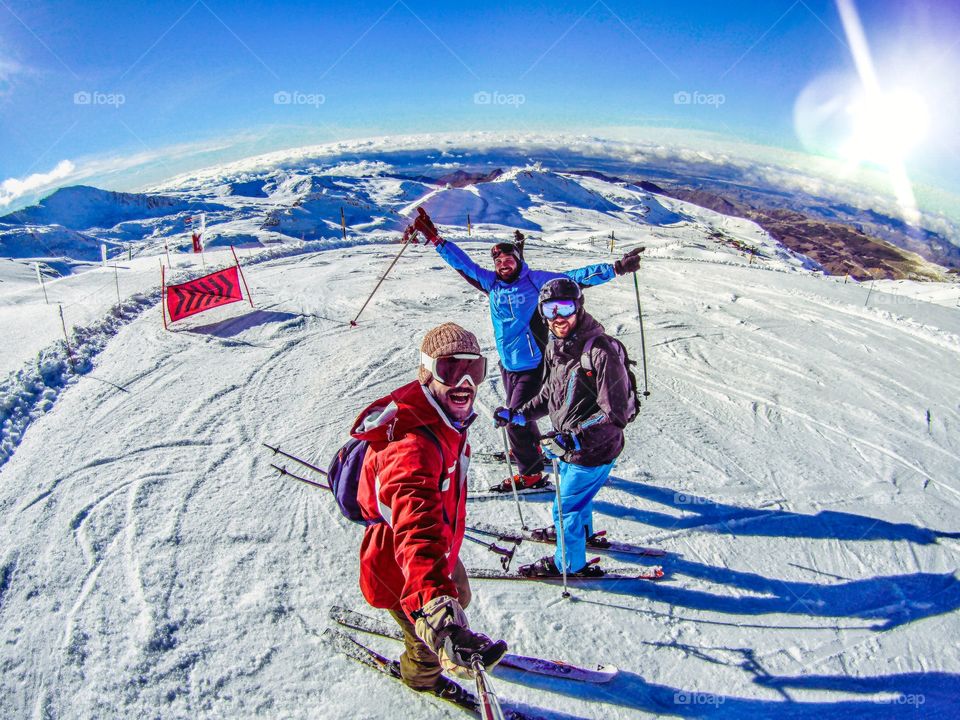 Friends skiing on snowy mountains on winter.