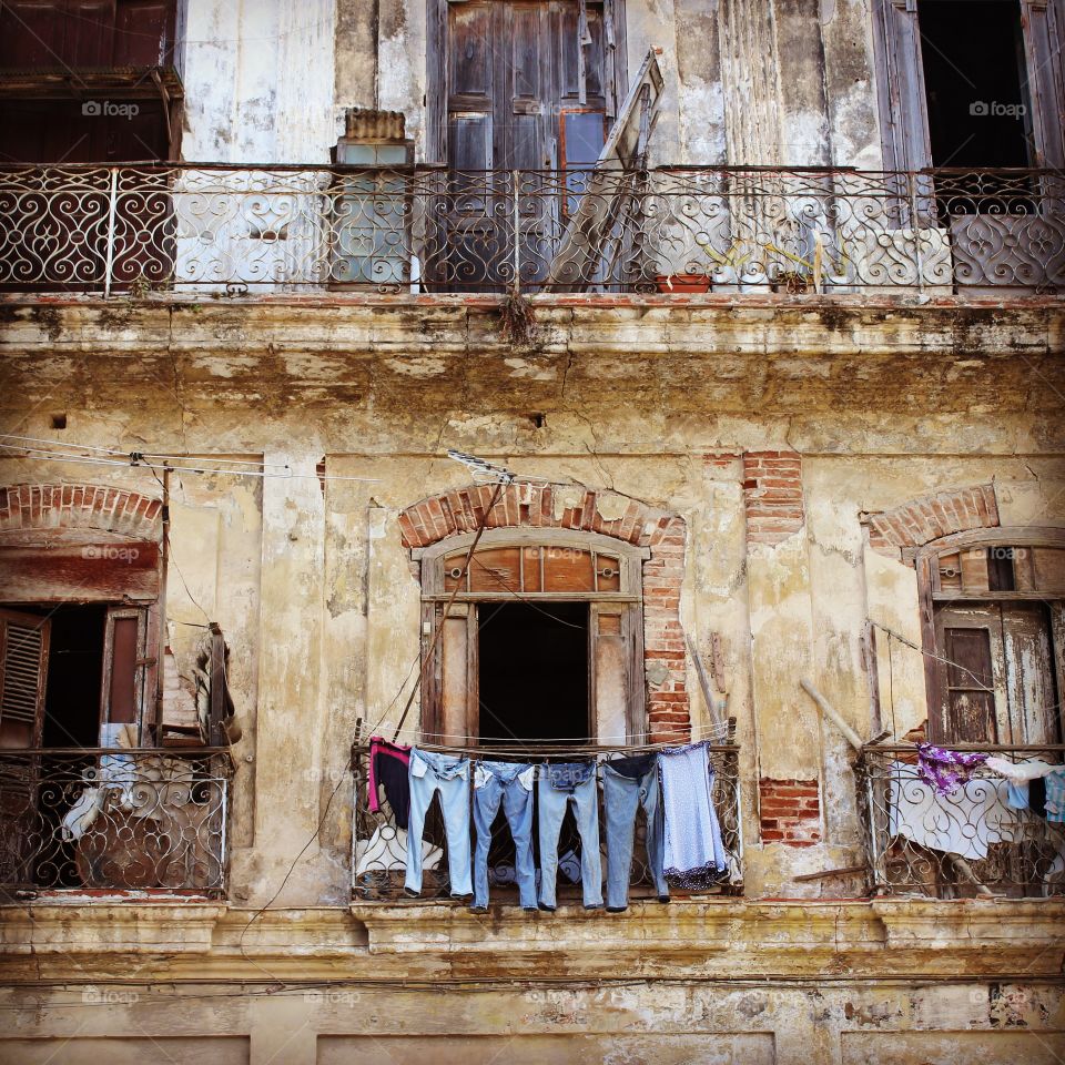 Selection of denim jeans hung out to dry from old building in Havana 