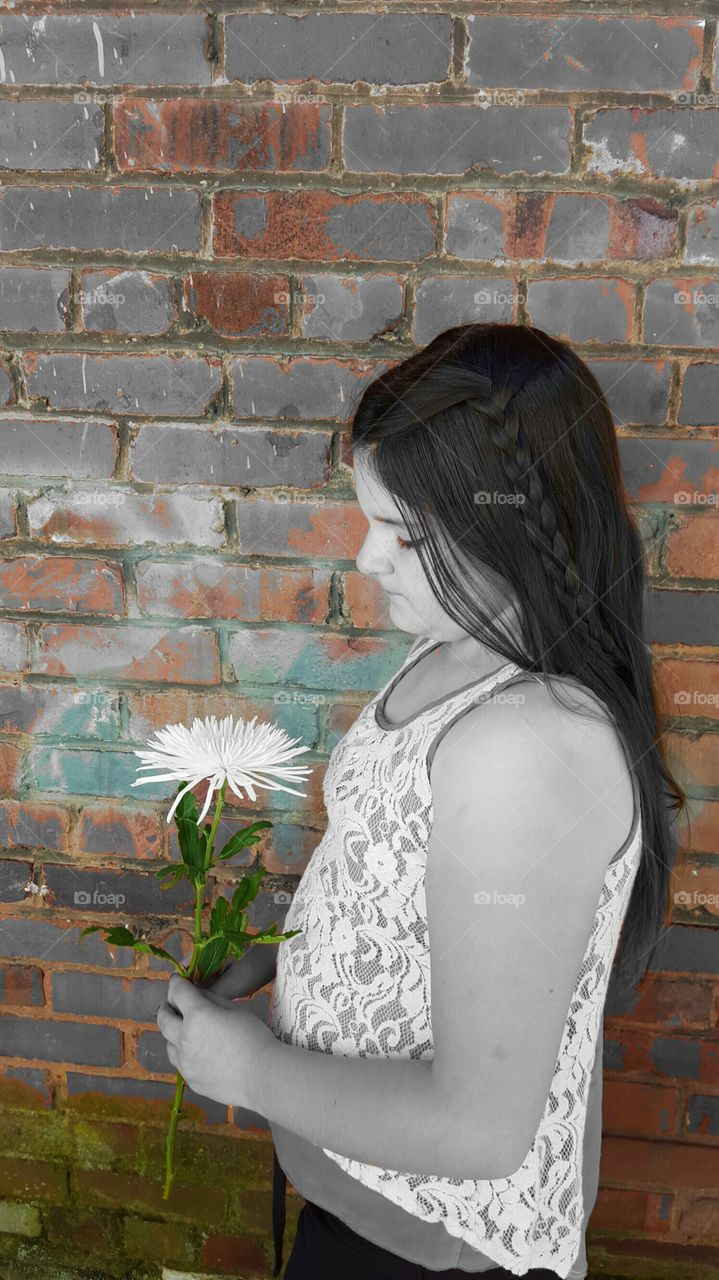 little girl with flower against brick