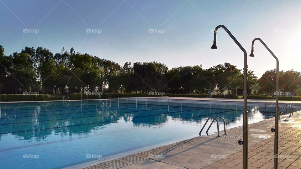 reflections in the swimming pool and two showers during the sunset