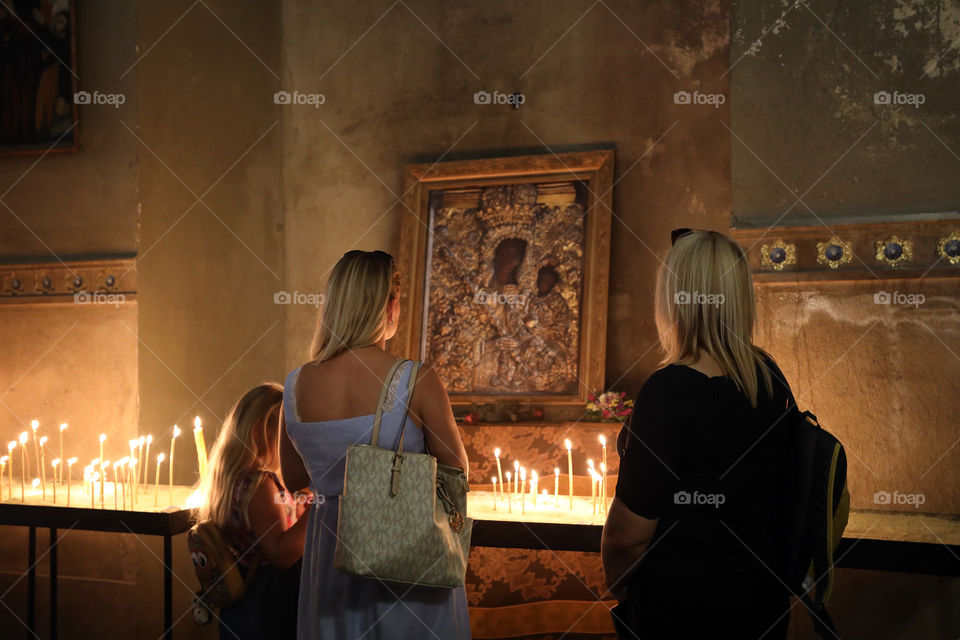 Two women and a girl contemplate an icon of the Madonna and child at the Armenian cathedral in Lviv, Ukraine