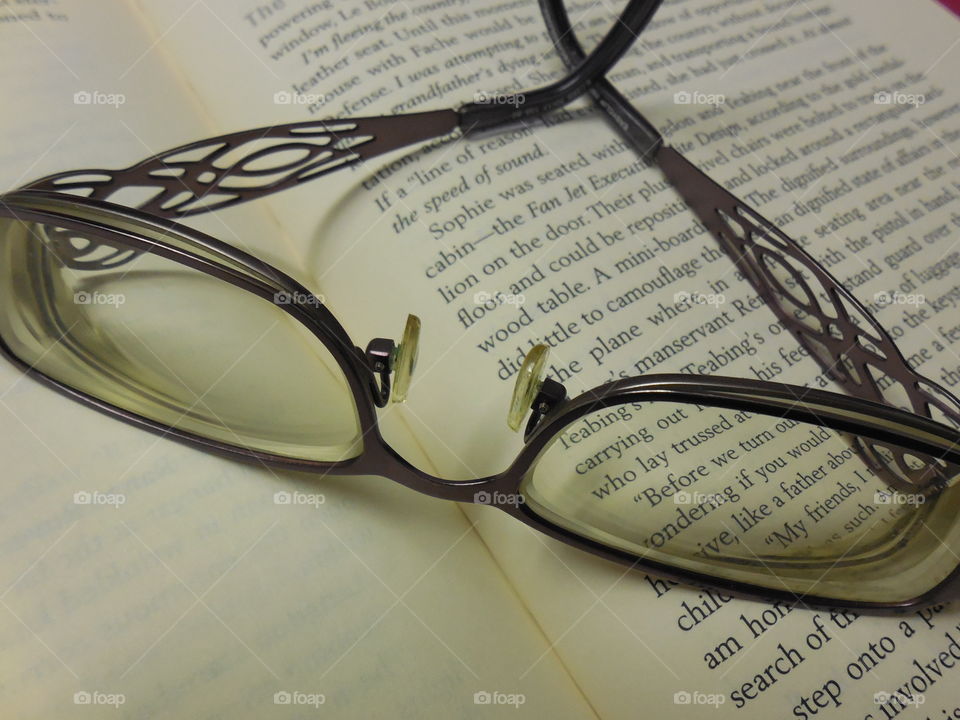 Purple glasses on book