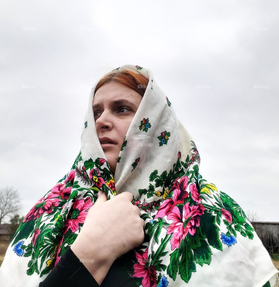 Portrait of a sad girl in a colored scarf