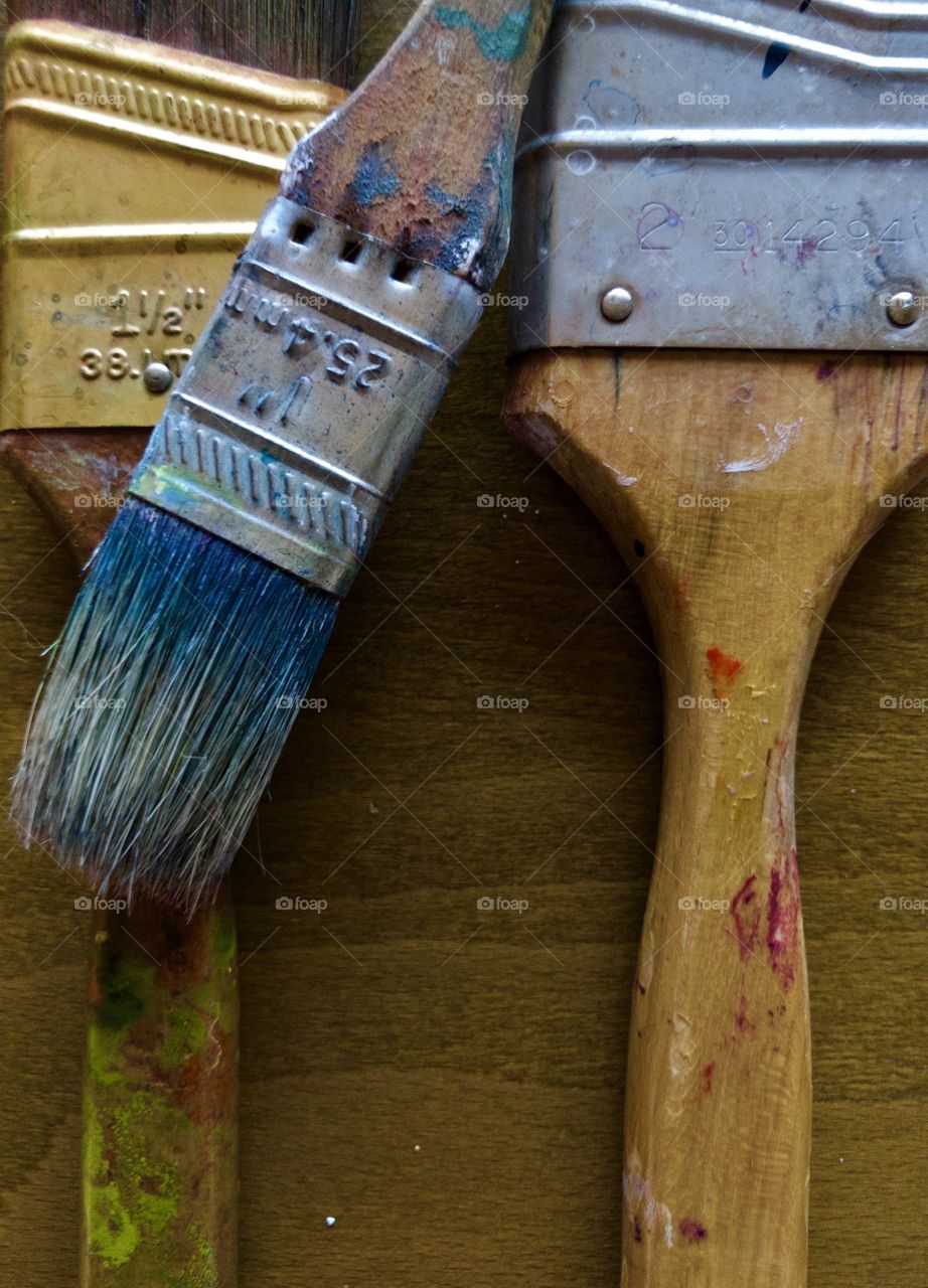 Used paintbrushes on wooden drafting table 
