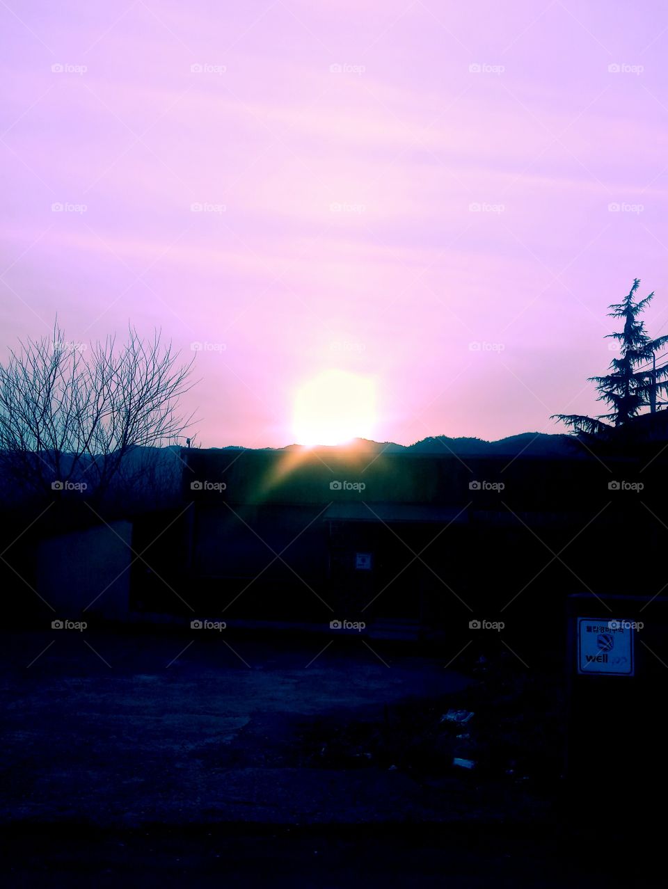 The beautiful and colorful Sunset in our place which almost be  covered  by mountains and the trees beside it.