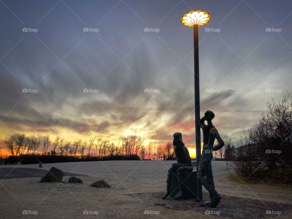 Evening walk by the pond.  Happened upon these two odd statues hanging by a light pole.   Seemed to be enjoying the sunset like me.