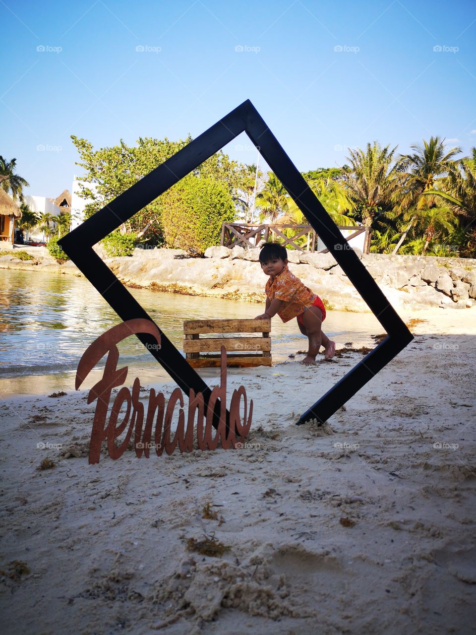 little and so adorable baby posing for the camera in a lost beach on the Caribbean, with clean water anda soft sand. perfect for a photoshoot