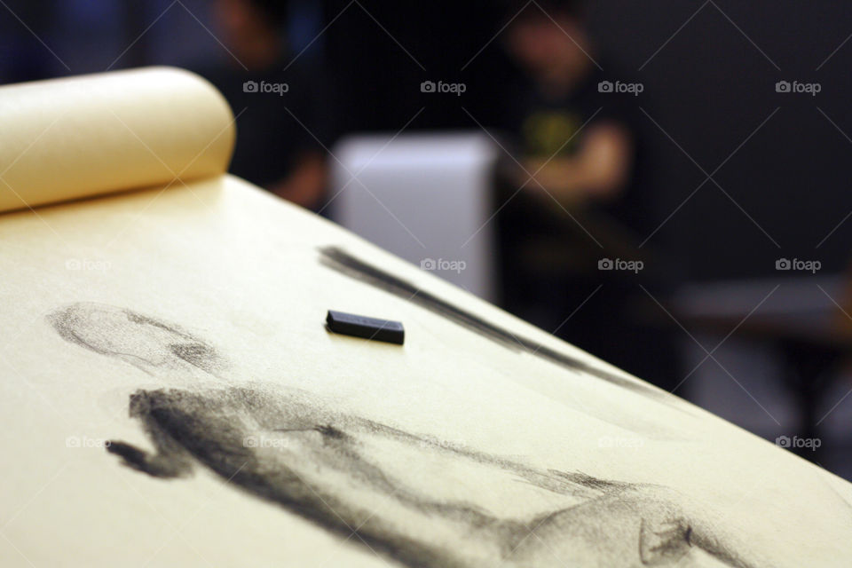 An artist has sketches a model in charcoal in the studio 