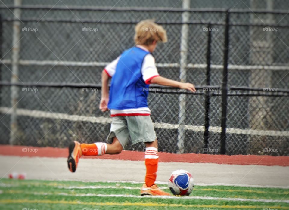 Boy Playing Soccer. Young Boy Kicking A Soccer Ball
