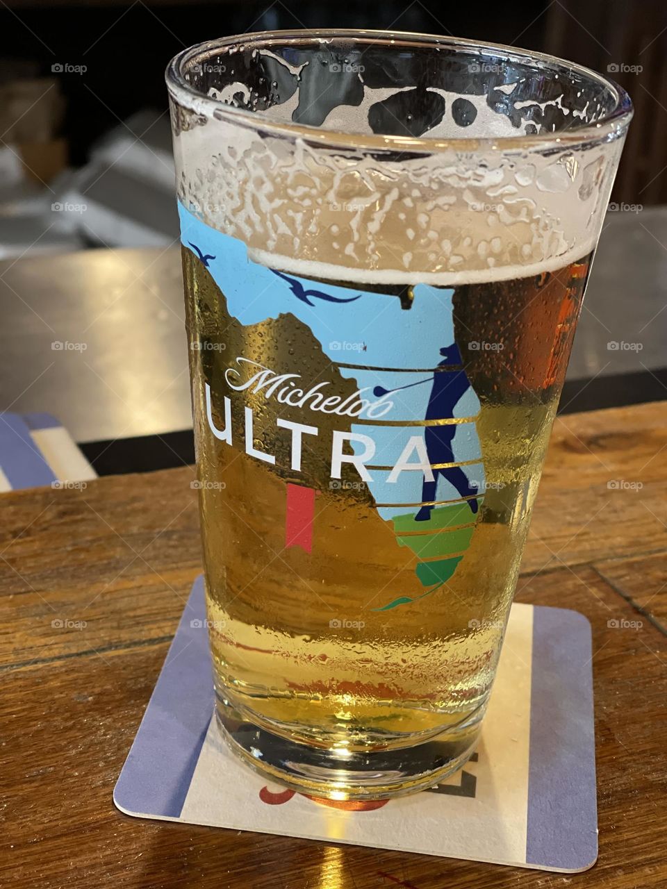 Cold beer in a Florida golf mug. Michelob Ultra in a glass.