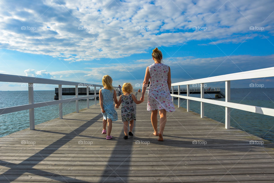 Mother with two doughters walking on a bridge at Ribban in Malmö Sweden.