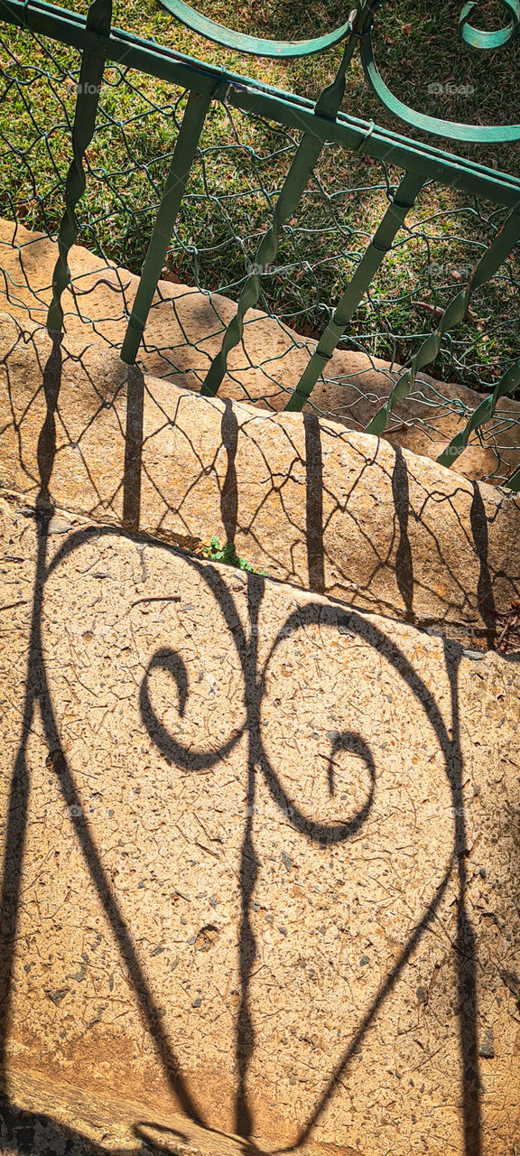 a garden-gate casting a shadow that looks like a heart