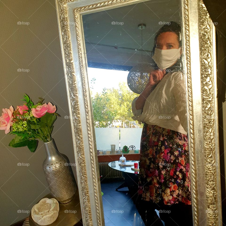 Looking in the mirror with a mouth mask.