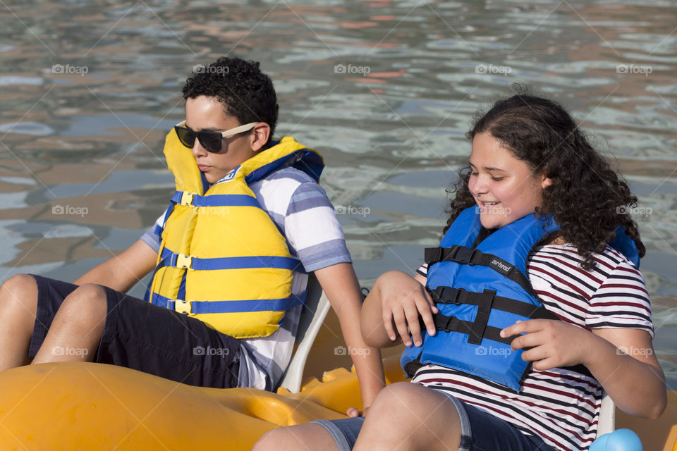 Siblings paddling boat