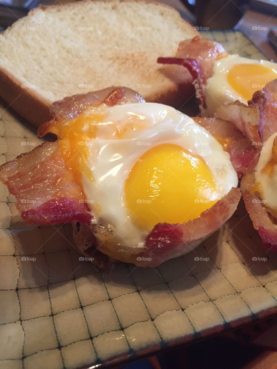 Cheesy eggs wrapped in bacon with toast