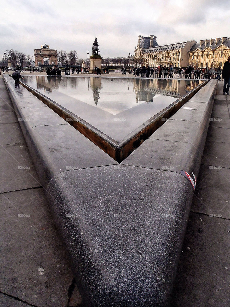 Reflection of buildings in the water at the Louvre Museum Paris