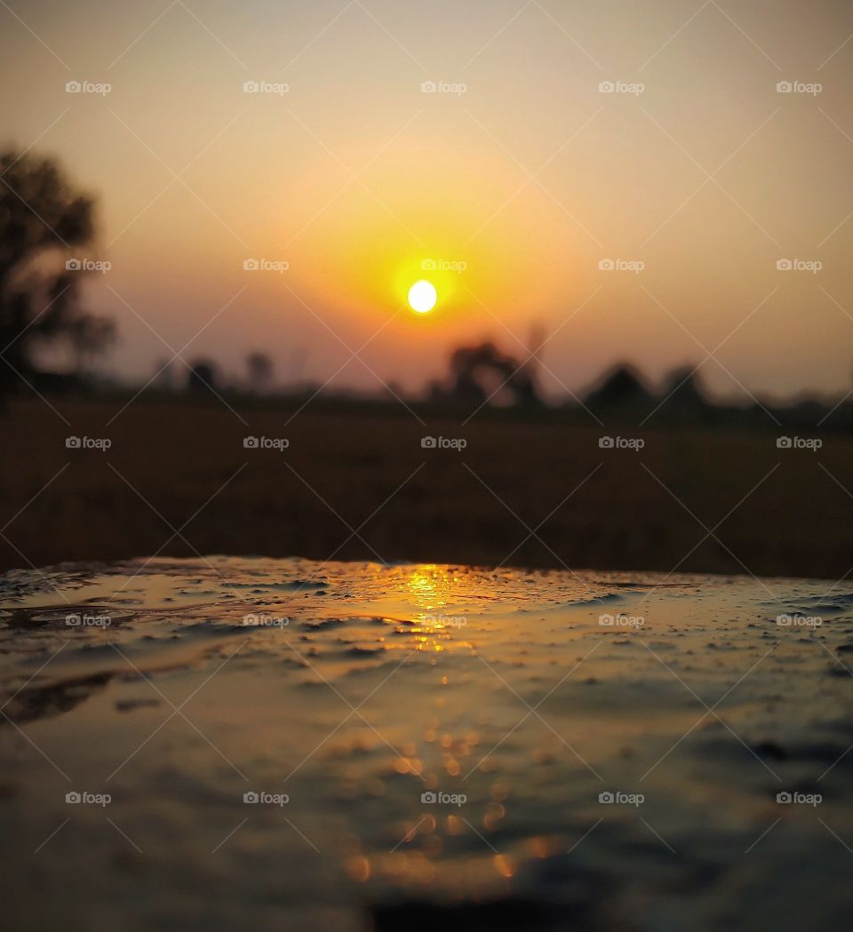 Sunset reflects the surface of ground.