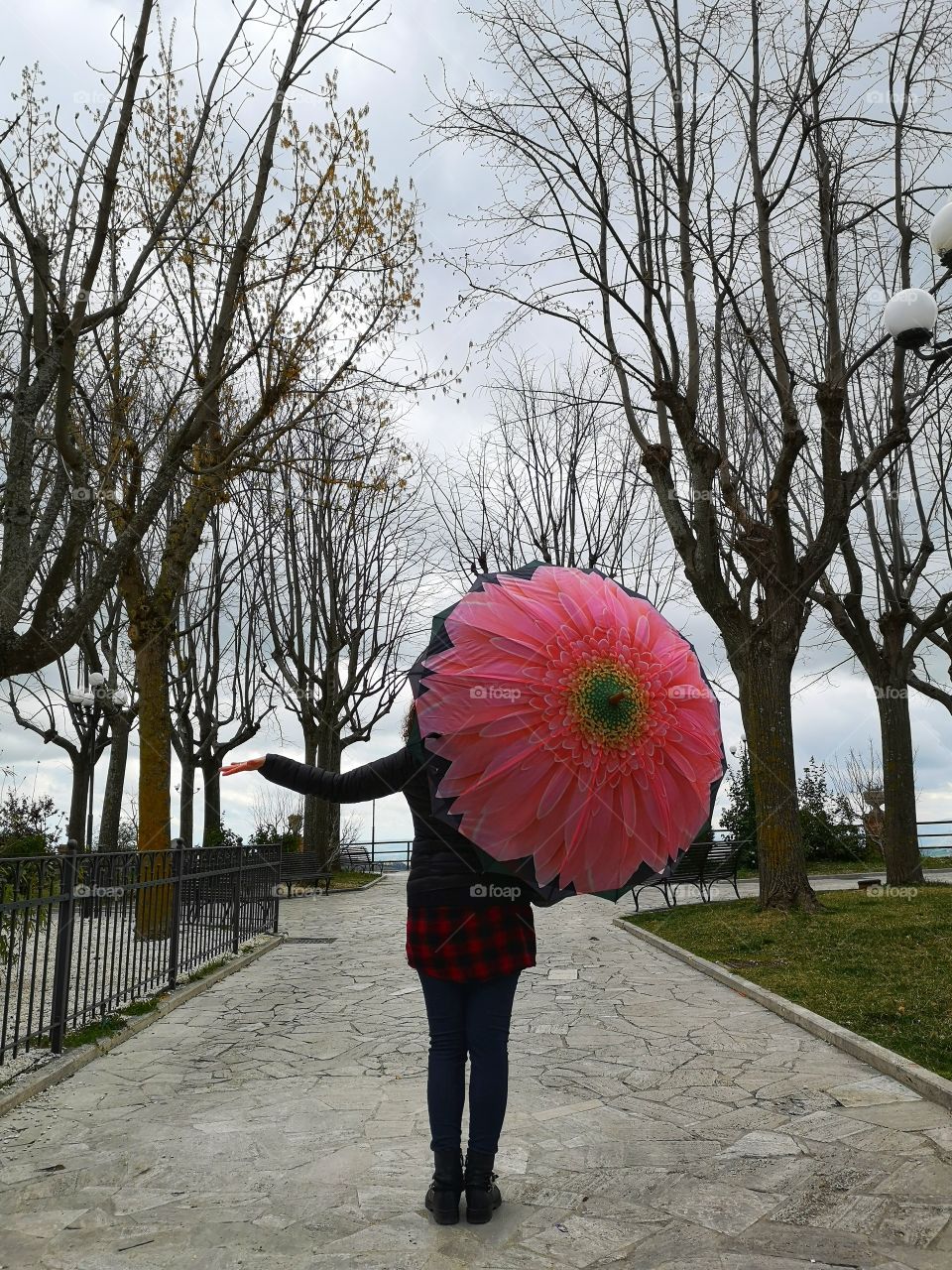 woman with colorful umbrella strolls in the rain