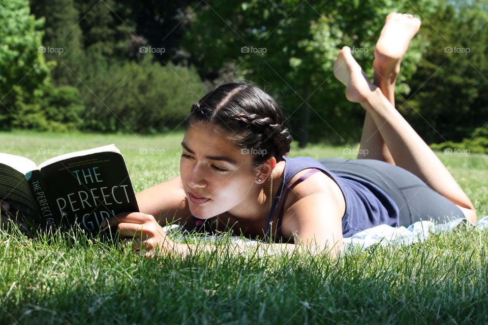 Young woman is reading a book in the park