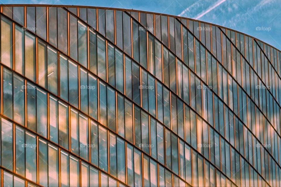 The colors of the sunset reflected in the glass facade of a house