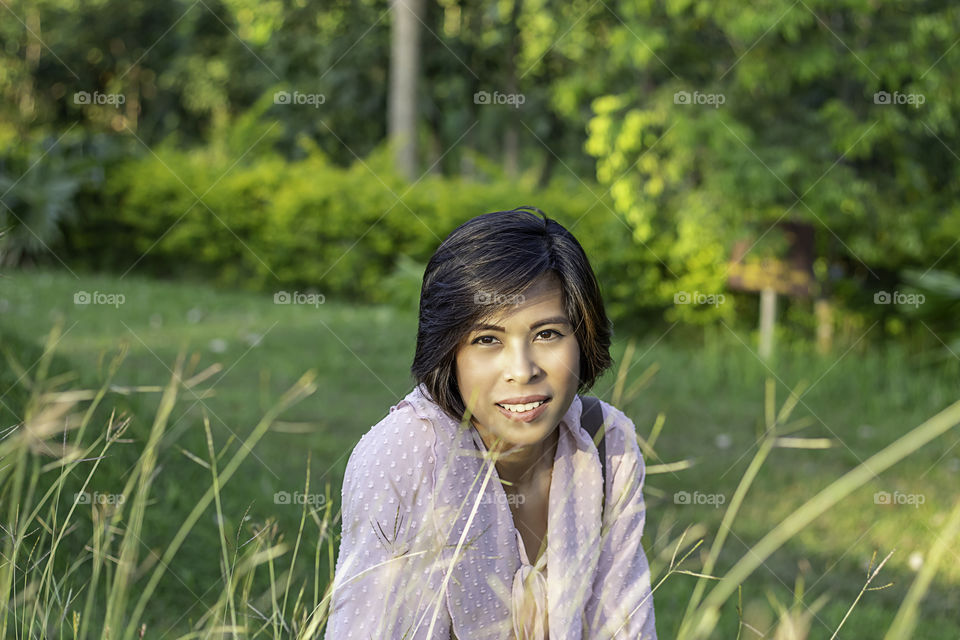 Portrait of Women with short hair brown skin Sitting on the gras