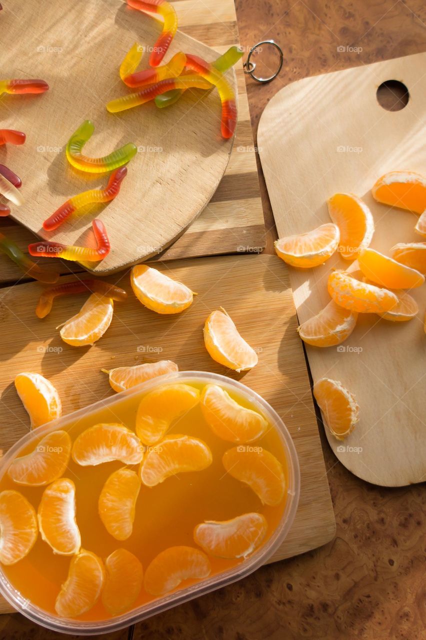 Delicious orange jelly with tangerine slices in a container and jelly worms.