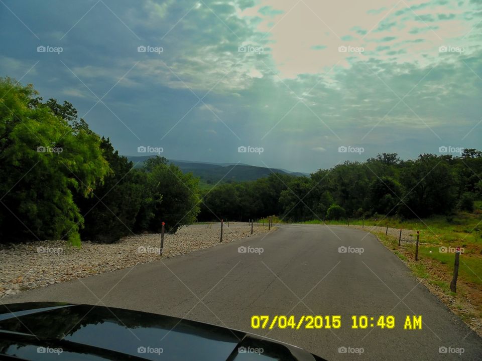 sunrays coming through. This is a picture of a Texas road that leads to a restaurant 🍴 called wildcatters located east of Graham Texas