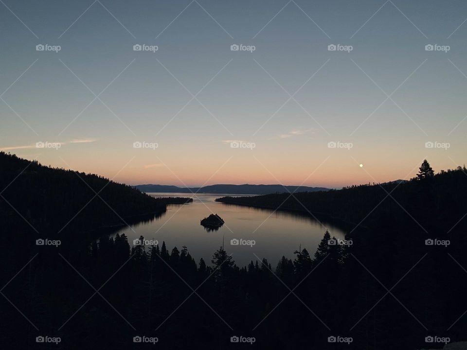 A sunset lights up Emerald Bay in Lake Tahoe, California at dusk