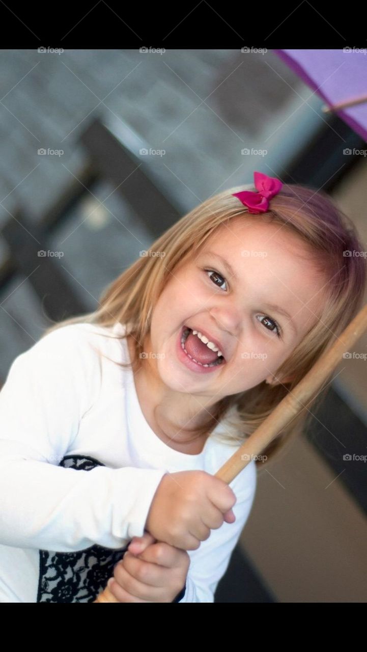 Little girl holding an umbrella and laughing