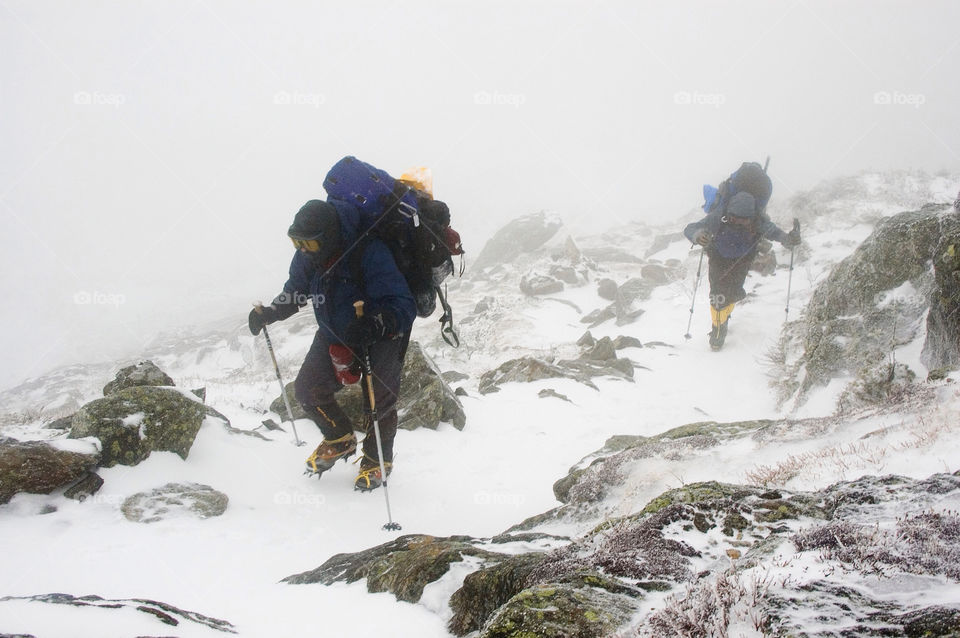 Backpackers struggling to climb over the summits of the presidential