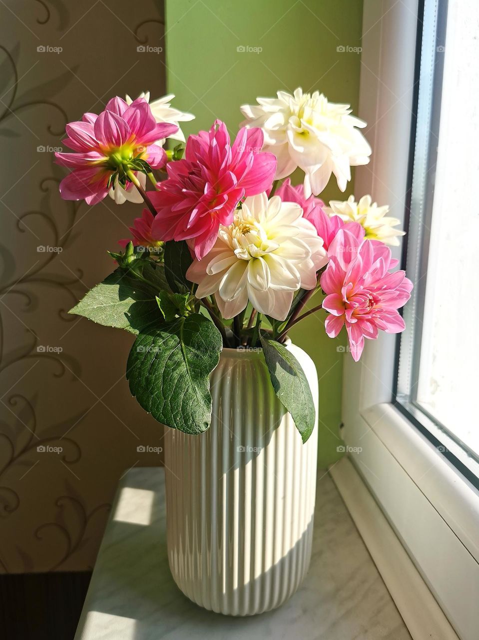 Bouquet of flowers in a vase by the window
