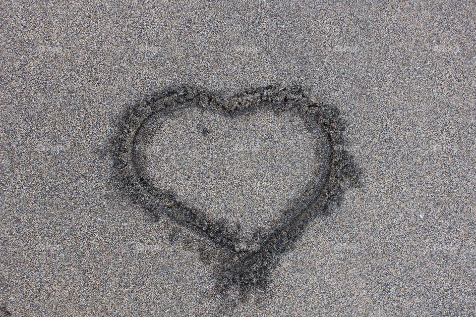 Heart on black sand