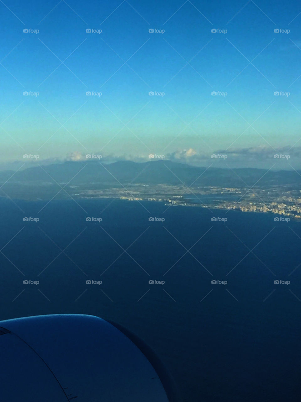 Panoramic view of Puerto Rico island from an airplane where you can also appreciate the blue of the tropical sky and the Atlantic Ocean.