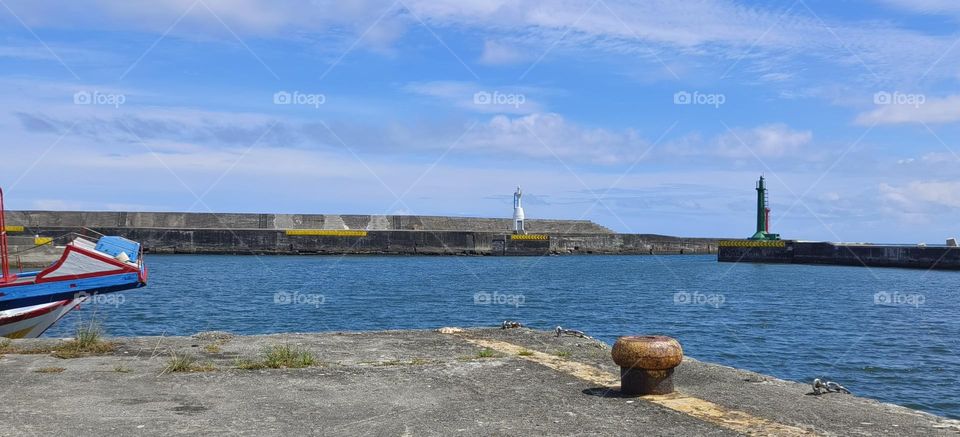 Lighthouse and blue sky with white clouds