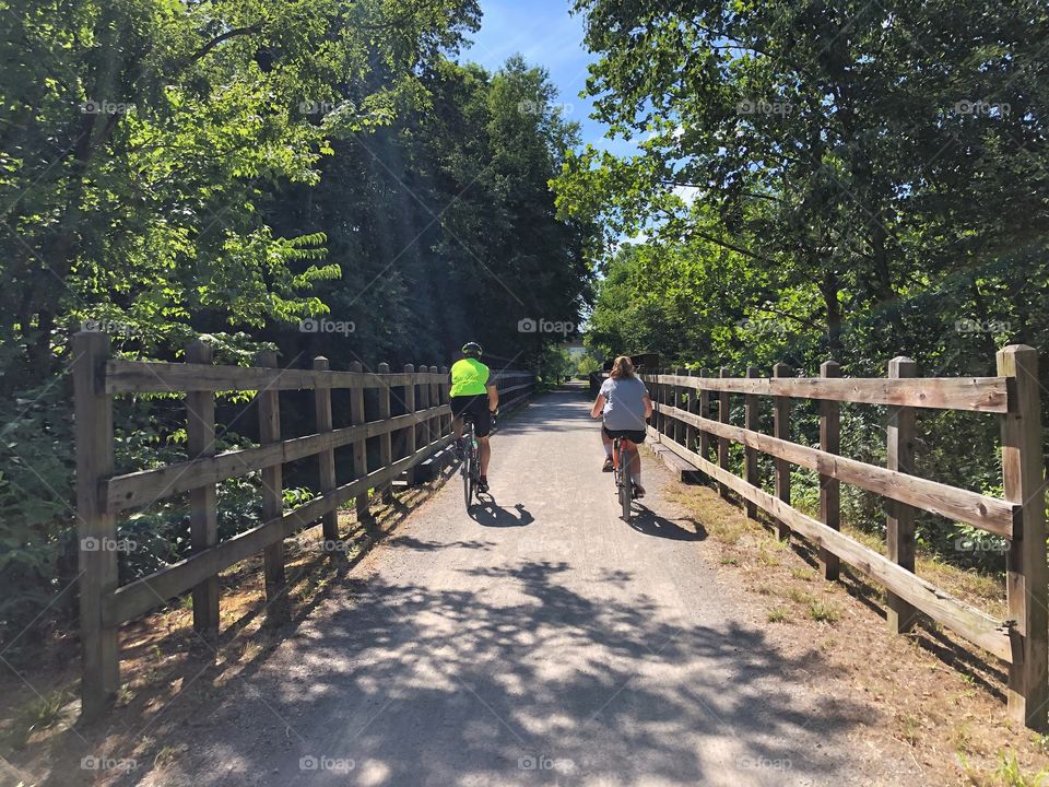 Two bicycle riders on a gravel trail in the summer