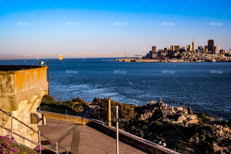 View of the San Francisco city skyline from Alcatraz Island with calm waters and clear skies 