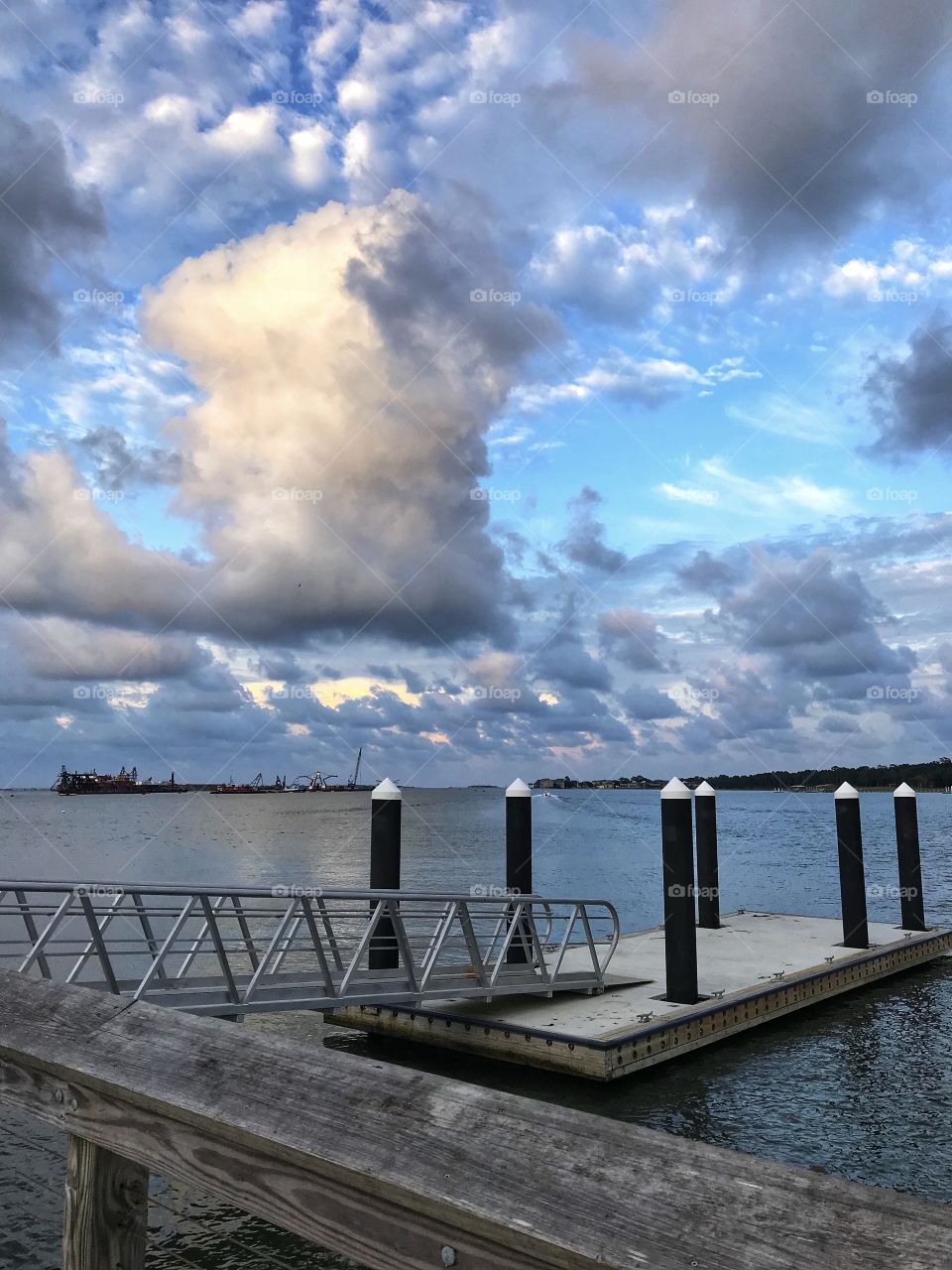 The peaceful harbor, floating dock, and dredging equipment viewed from the pier 