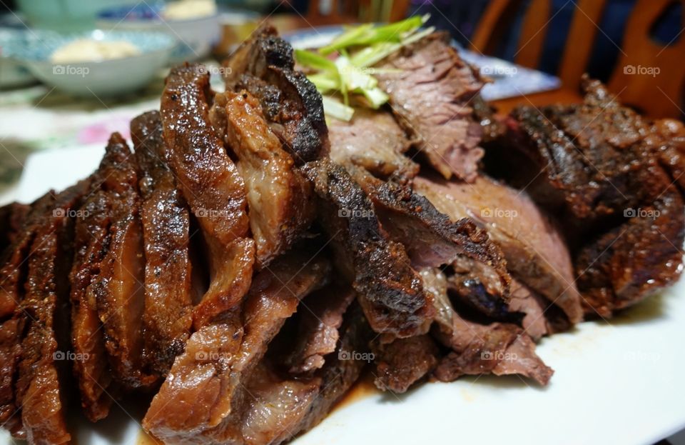 Homemade BBQ beef brisket. Freshly roasted from the oven and sliced into ready-to-serve pieces. Catering concept.