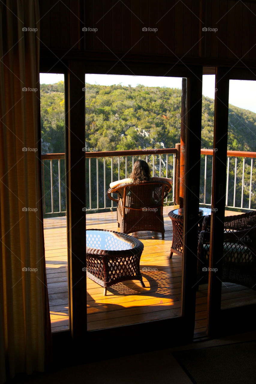 Window view - woman sitting enjoying the view with a book