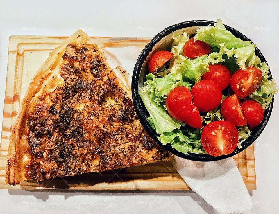 potato tortilla snack with cheese accompanied by cherry tomato salad with lettuce