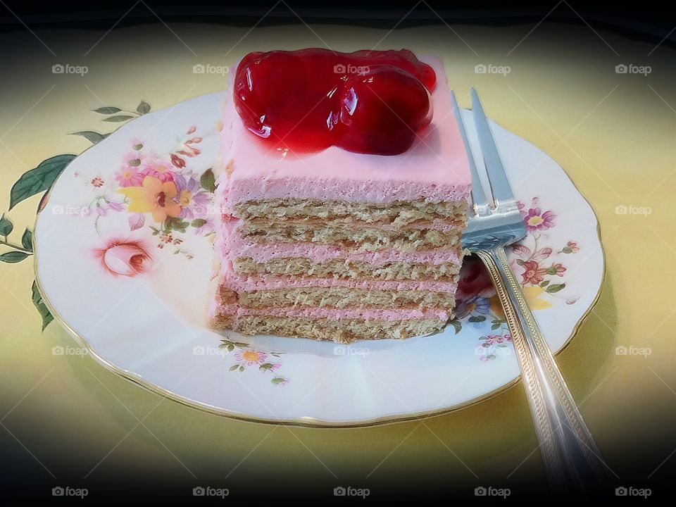A beautiful cherry layer cake cut into squares.