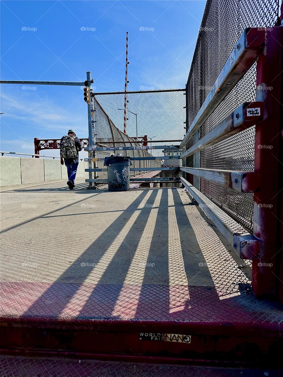 Ascending the red metal staircase of the “Pulaski Bridge” at “Newtown Creek” in LIC, Queens we never know what image will present itself. Depending on the time the sun casts shadows onto the pavement of various shapes. 2024. Hypnotic Productions