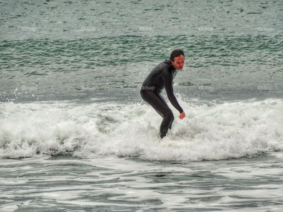 Surfer Coasting In To Shore. California Surfing
