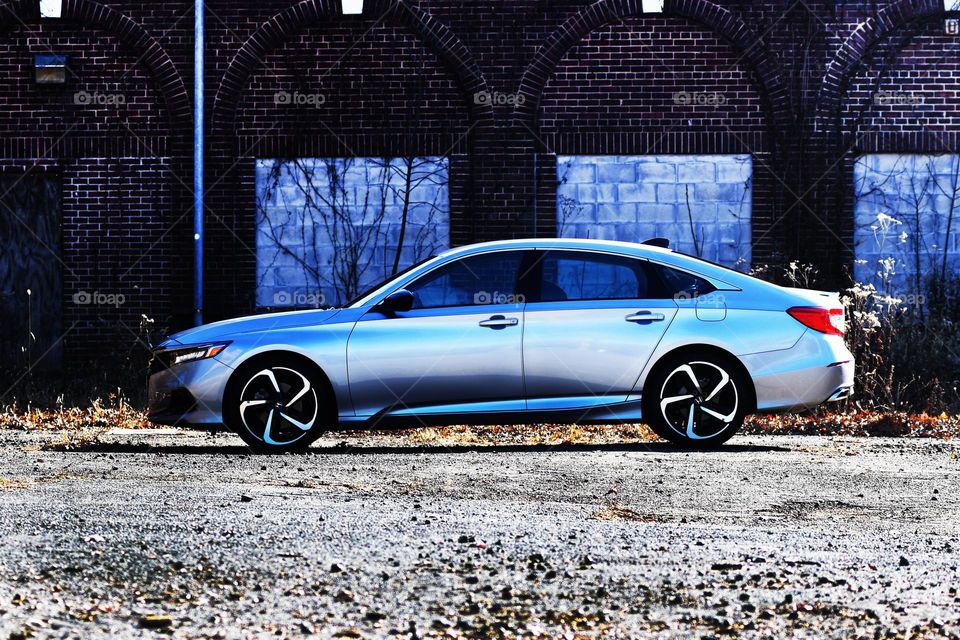 A 2021 sport special edition Honda Accord sits parked in a gravel lot of a mysterious abandoned asylum.
