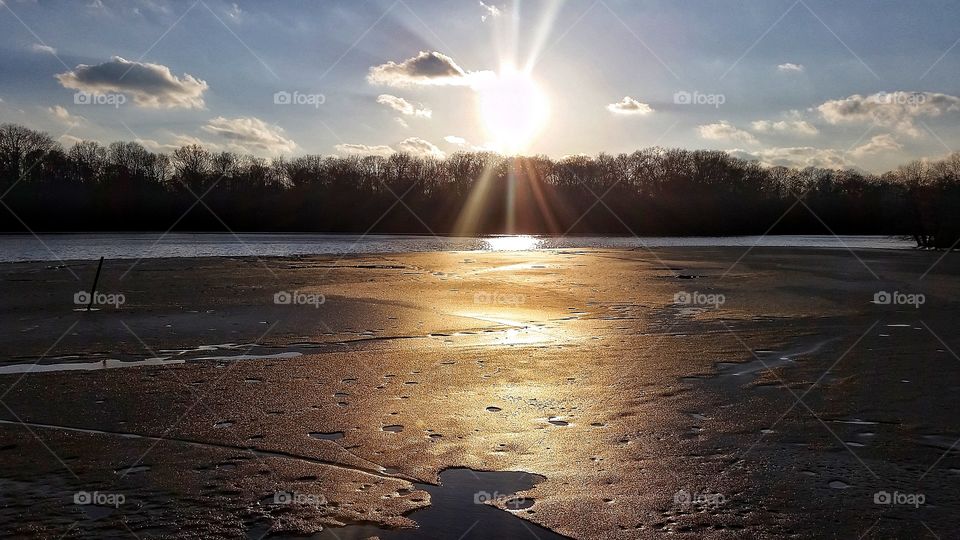Sunset over thawing lake
