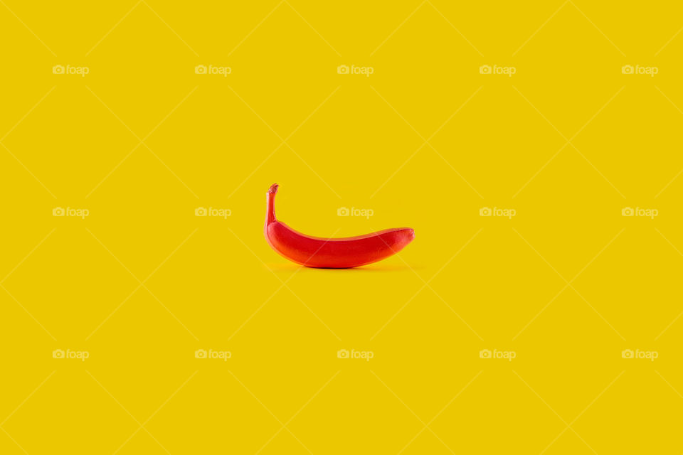 Red banana on yellow bacground. Minimal food concept